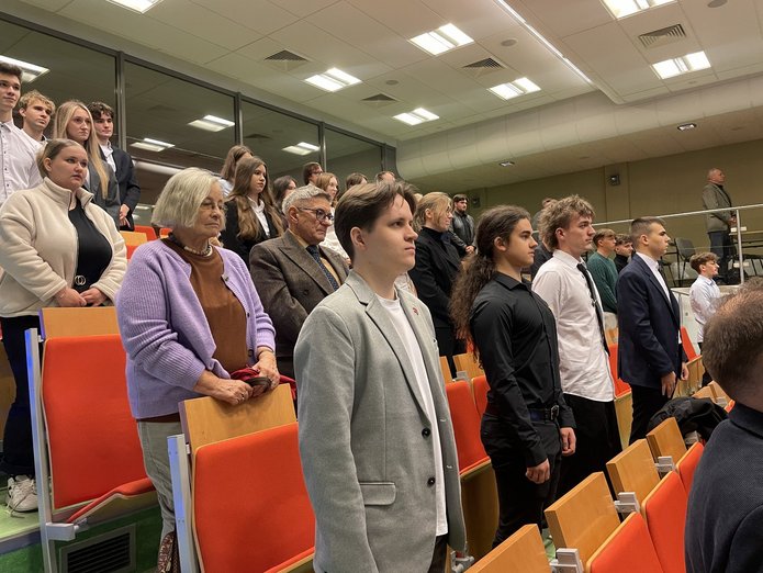 stojący studenci i pracownicy na auli podczas inauguracji roku akademickiego