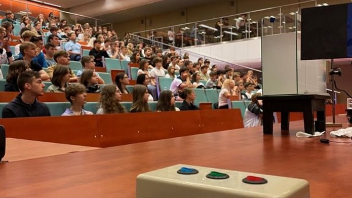 the assembly hall where the meeting participants are present, and there is a device on the lecture counter