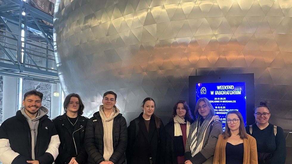 Na zdjęciu uczestnicy spotkania stojący przed kinem sferycznym. Zdjęcie przedstawia zarówno kobiety, jak i mężczyzn.