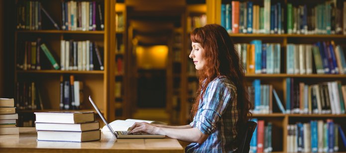 Kobieta w bibliotece z laptopem